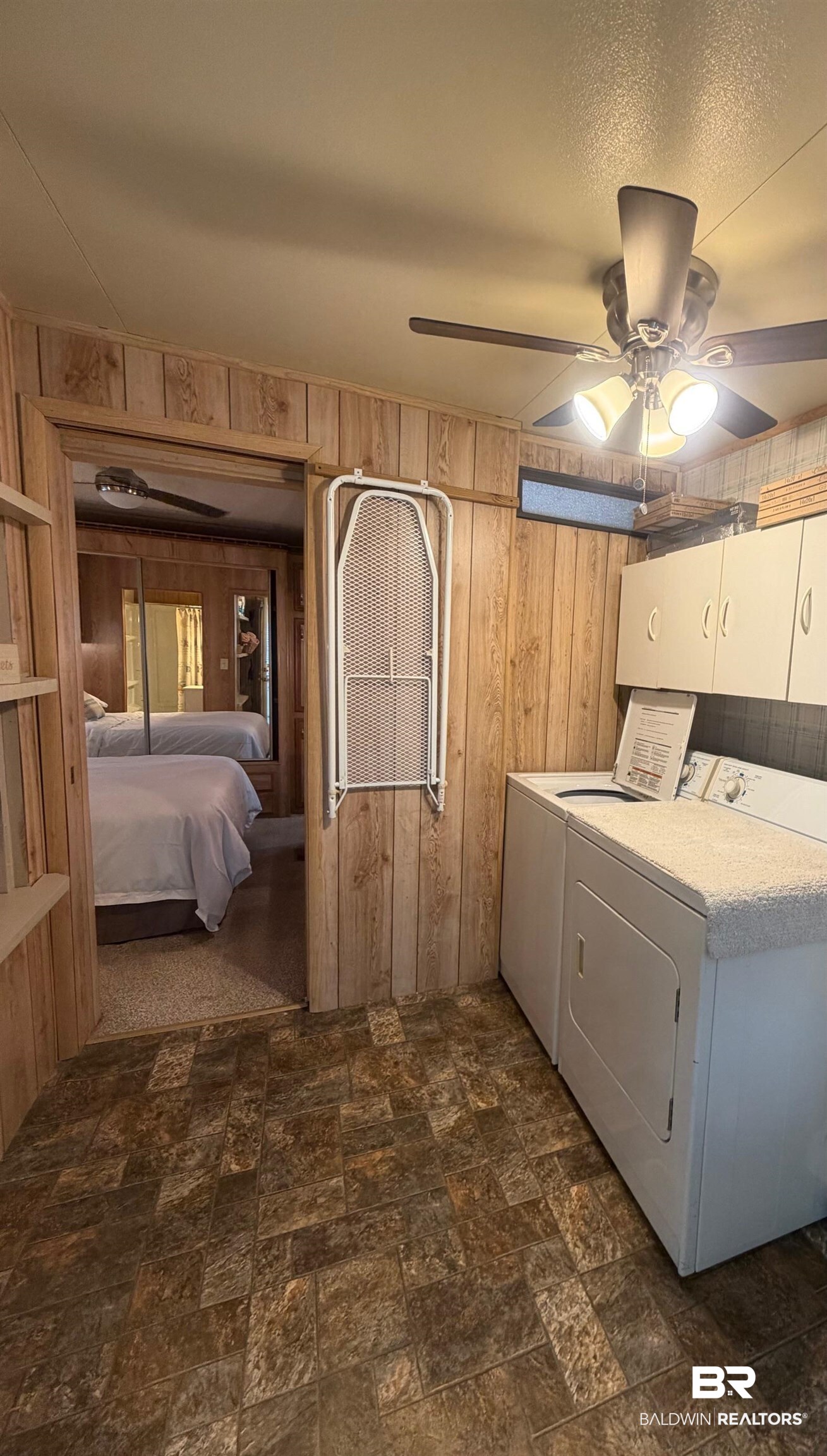 685 Escambia Loop Lillian, AL 36549 - Photo 19 of 43 Laundry room with wood walls, stone finish floors, cabinet space, a ceiling fan, and washing machine and dryer