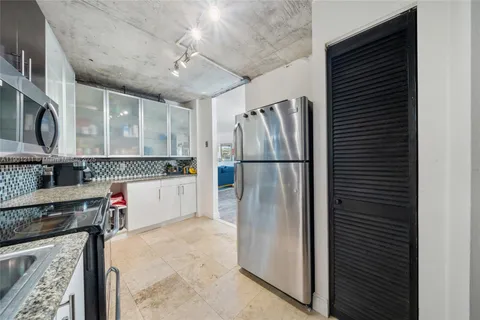a kitchen with stainless steel appliances granite countertop a refrigerator and a stove top oven