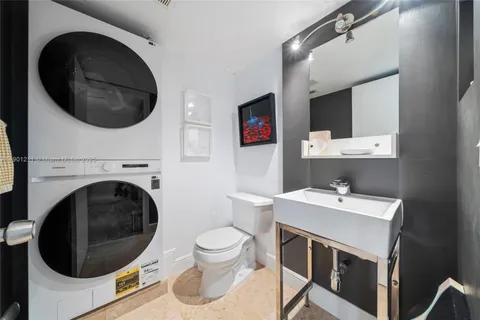 a bathroom with a washing machine and sink