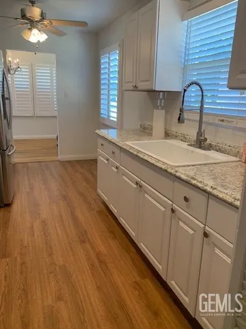 a kitchen with granite countertop wooden cabinets a sink and dishwasher