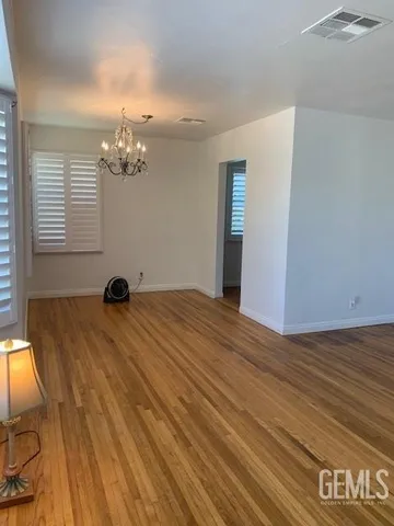 a view of a livingroom with a flesh screen tv and wooden floor