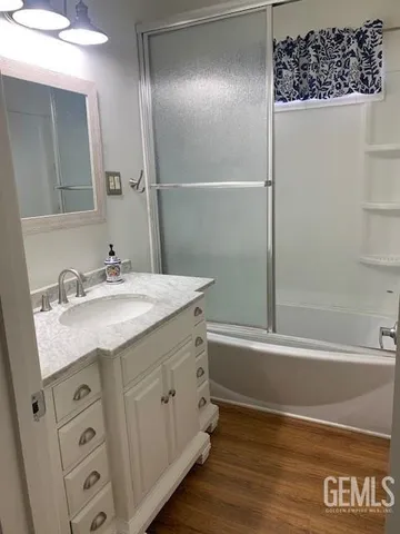 a bathroom with a granite countertop sink a mirror and a bathtub
