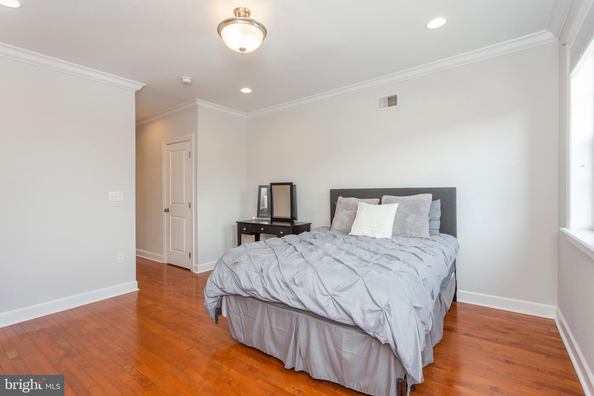 2118 Ellsworth Street Philadelphia, PA 19146 - Photo 21 of 32 a bedroom with a bed and wooden floor