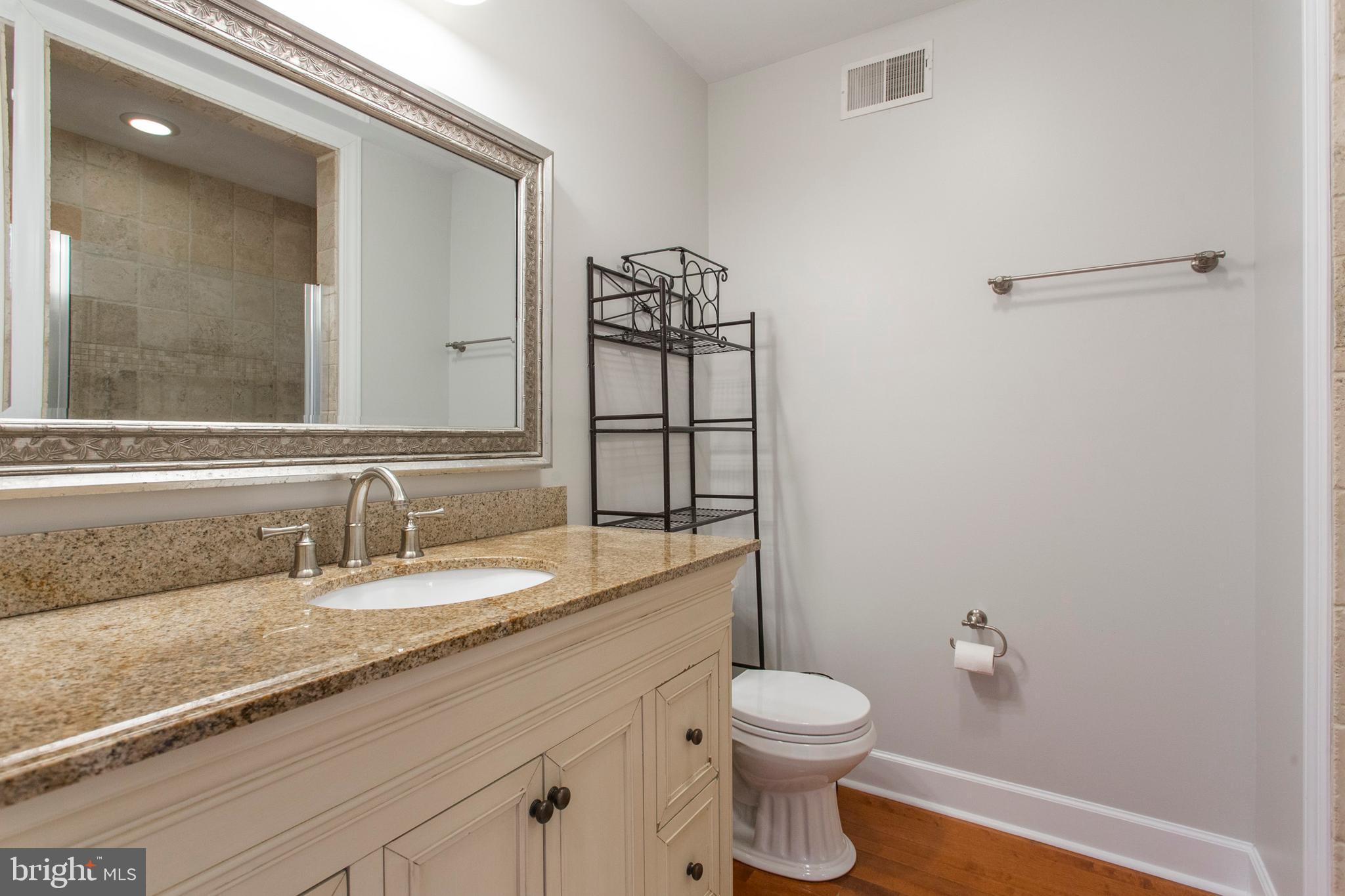 2118 Ellsworth Street Philadelphia, PA 19146 - Photo 22 of 32 a bathroom with a granite countertop toilet sink and mirror
