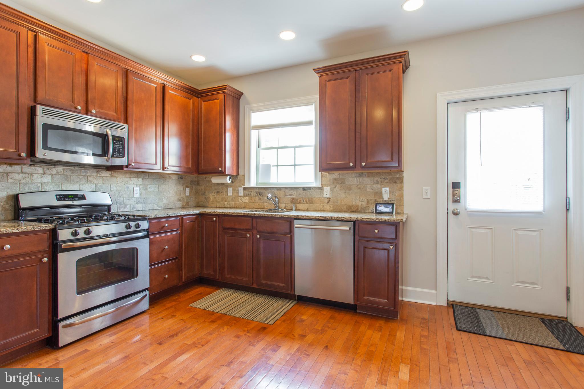 2118 Ellsworth Street Philadelphia, PA 19146 - Photo 10 of 32 a kitchen with stainless steel appliances granite countertop a stove a sink and a microwave