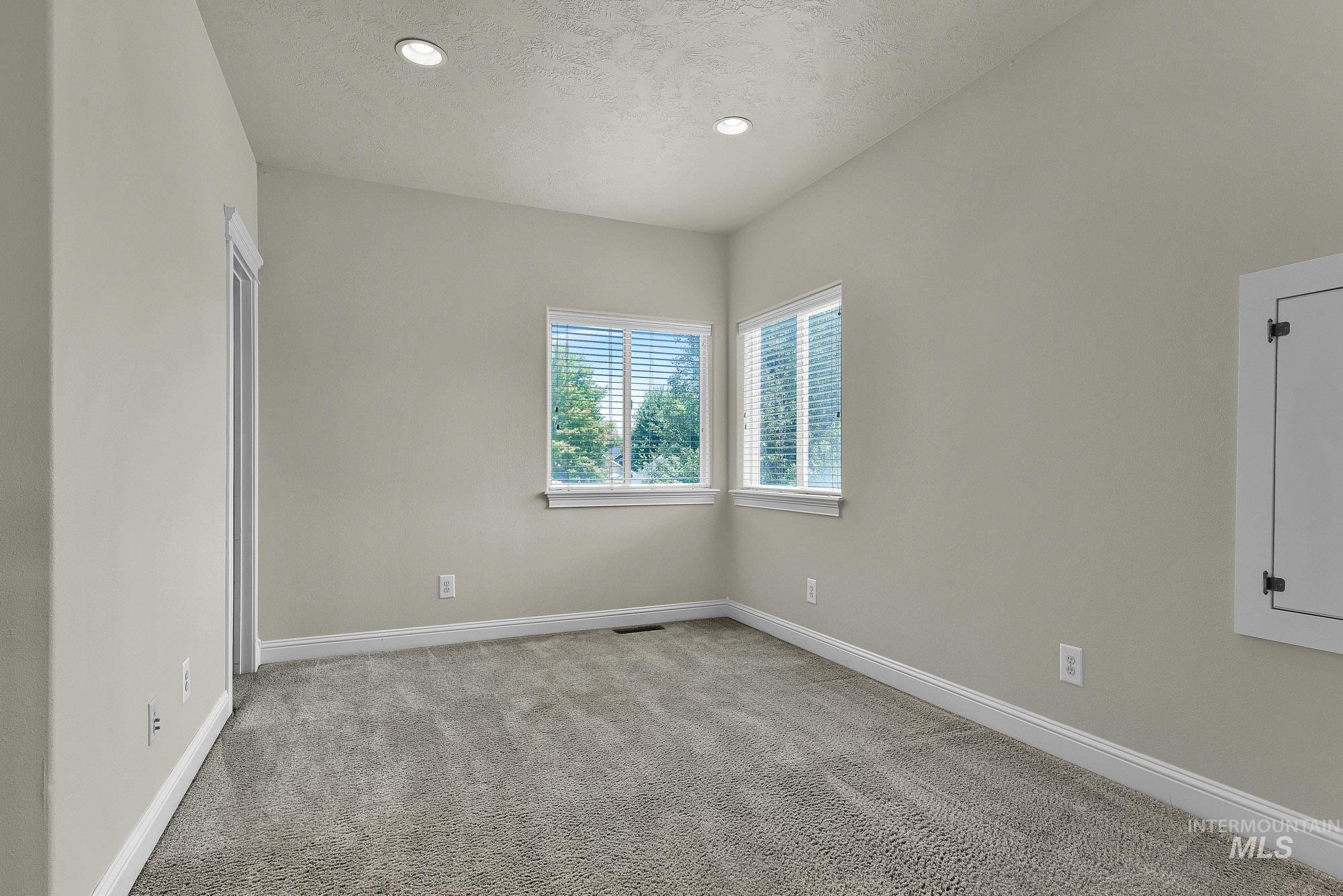 2172 West Cedar Grove Street Meridian, ID 83646 - Photo 27 of 49 Carpeted room featuring two windows with blinds, recessed lighting, and a white baseboard trim