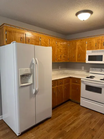 a kitchen with a refrigerator sink and cabinets