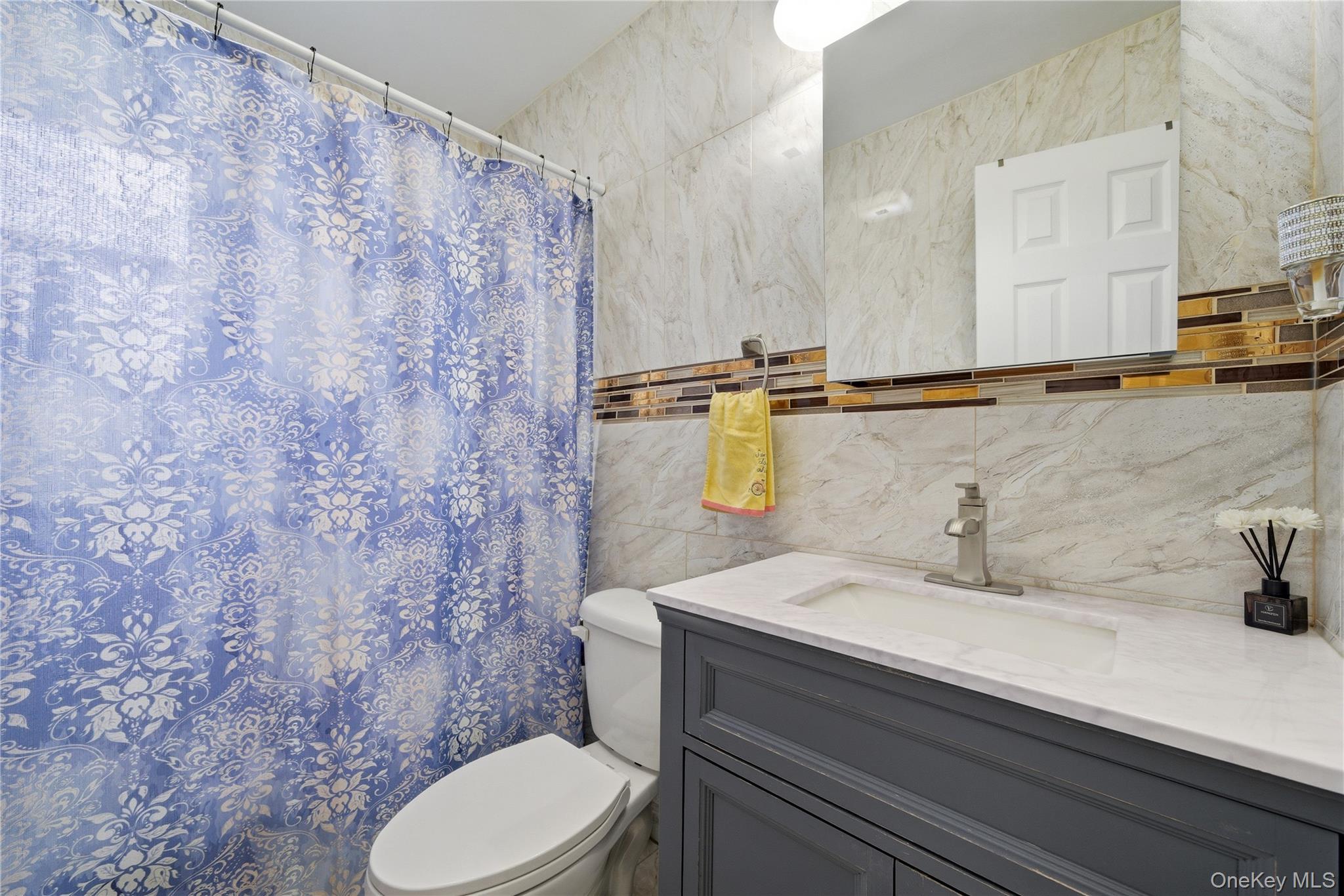 50 Ridge Lane Levittown, NY 11756 - Photo 15 of 27 a bathroom with a sink a toilet and mirror