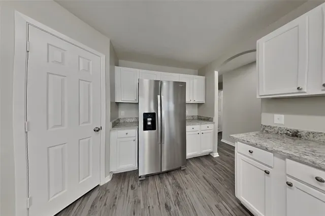 a kitchen with a refrigerator and a stove top oven
