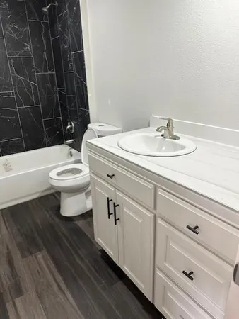 a bathroom with a sink a toilet and shower
