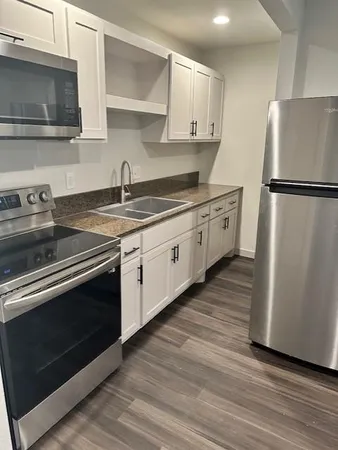 a kitchen with stainless steel appliances granite countertop a sink stove and refrigerator