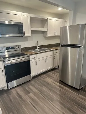 a kitchen with stainless steel appliances granite countertop a stove a refrigerator and a microwave