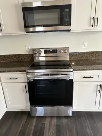 a stove top oven sitting inside of a kitchen with stainless steel appliances