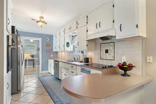 a kitchen with stainless steel appliances granite countertop a sink dishwasher stove and refrigerator with cabinets