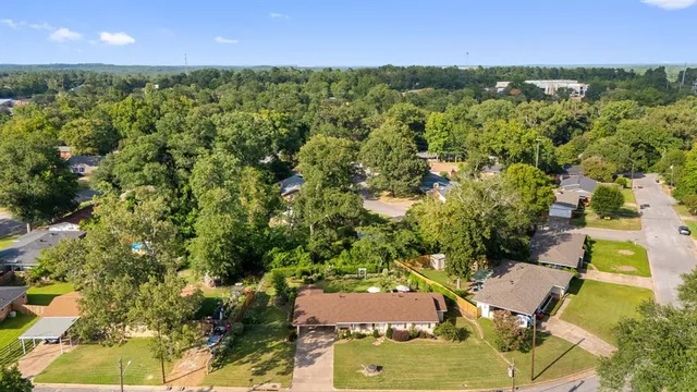 an aerial view of residential houses with outdoor space and trees
