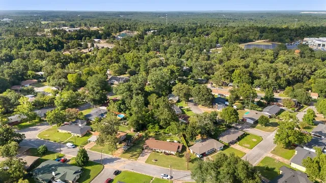 an aerial view of residential houses with outdoor space and trees