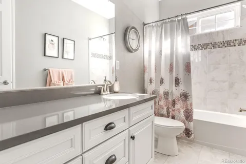a bathroom with a granite countertop sink mirror vanity and toilet