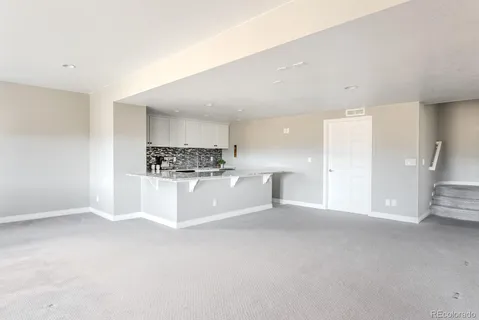 a large white kitchen with kitchen island a sink a stove a refrigerator and white cabinets