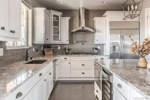 a kitchen with granite countertop a sink stainless steel appliances and cabinets