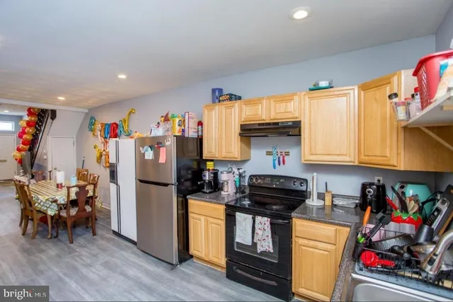 a kitchen with stainless steel appliances granite countertop a refrigerator and a stove top oven