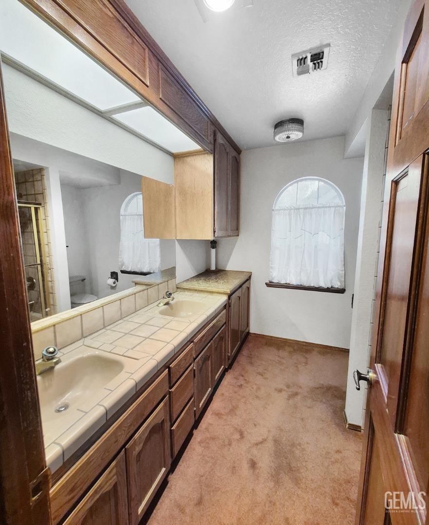 Undisclosed Address Lancaster, CA 93536 - Photo 18 of 22 a spacious bathroom with a granite countertop sink and a mirror