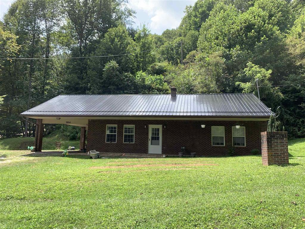 384 Camp Creek Road Northwest Riner, VA 24149 - Photo 3 of 12 a front view of a house with a garden