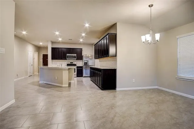 a view of kitchen with microwave a stove and cabinets