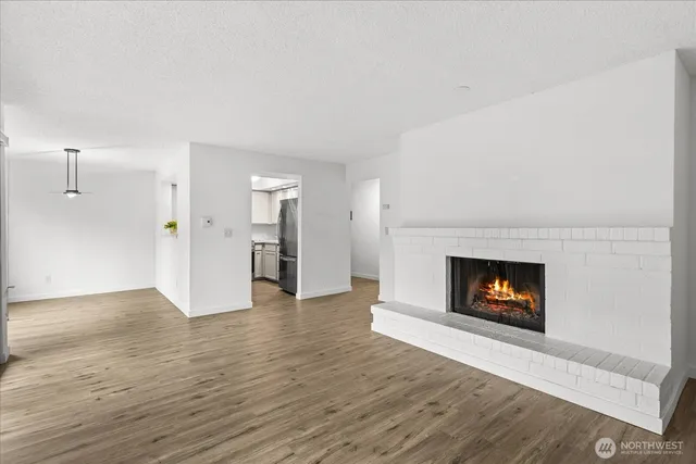 a view of an empty room with a fireplace and a window