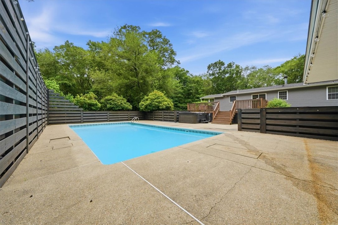 214 Anan Wade Road Glocester, RI 02857 - Photo 38 of 50 The entire pool area feels especially private and resort-like, enhanced by a striking 10-foot privacy fence at the rear and a beautiful backdrop of mature trees and landscaping. Whether you are hosting summer gatherings, enjoying a quiet evening soak, or spending the day by the pool, this outdoor space is a rare and exceptional amenity.