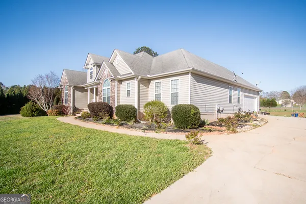 a view of a house with a yard and potted plants