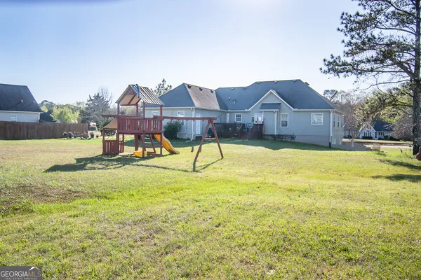 a view of a house with a big yard and large trees