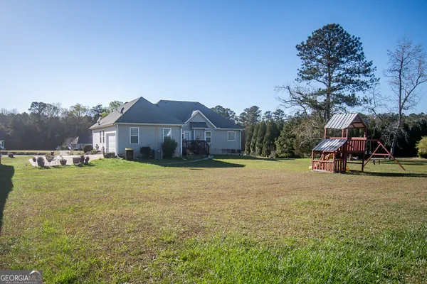 a view of a large house with a big yard and large trees