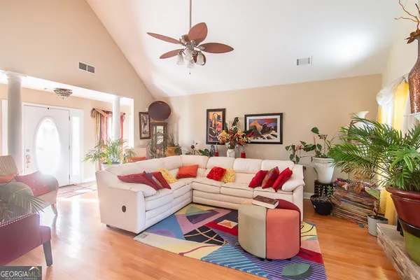 a living room with furniture kitchen view and a large window