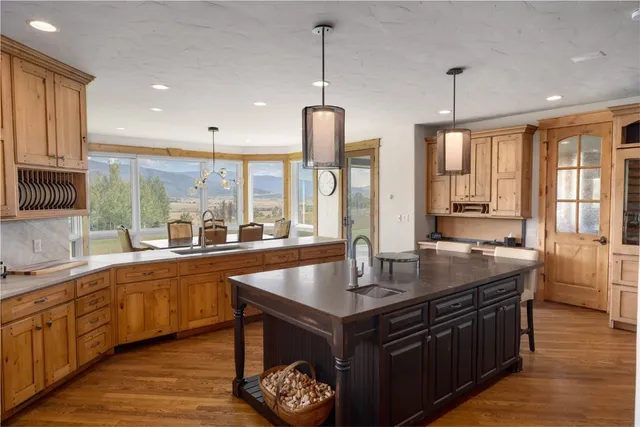 a kitchen with stainless steel appliances granite countertop a sink a stove and a wooden floors