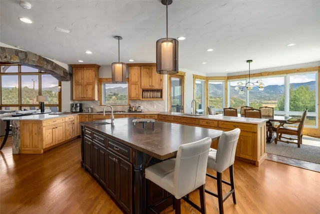 a kitchen with stainless steel appliances granite countertop a kitchen island a stove and a wooden floors