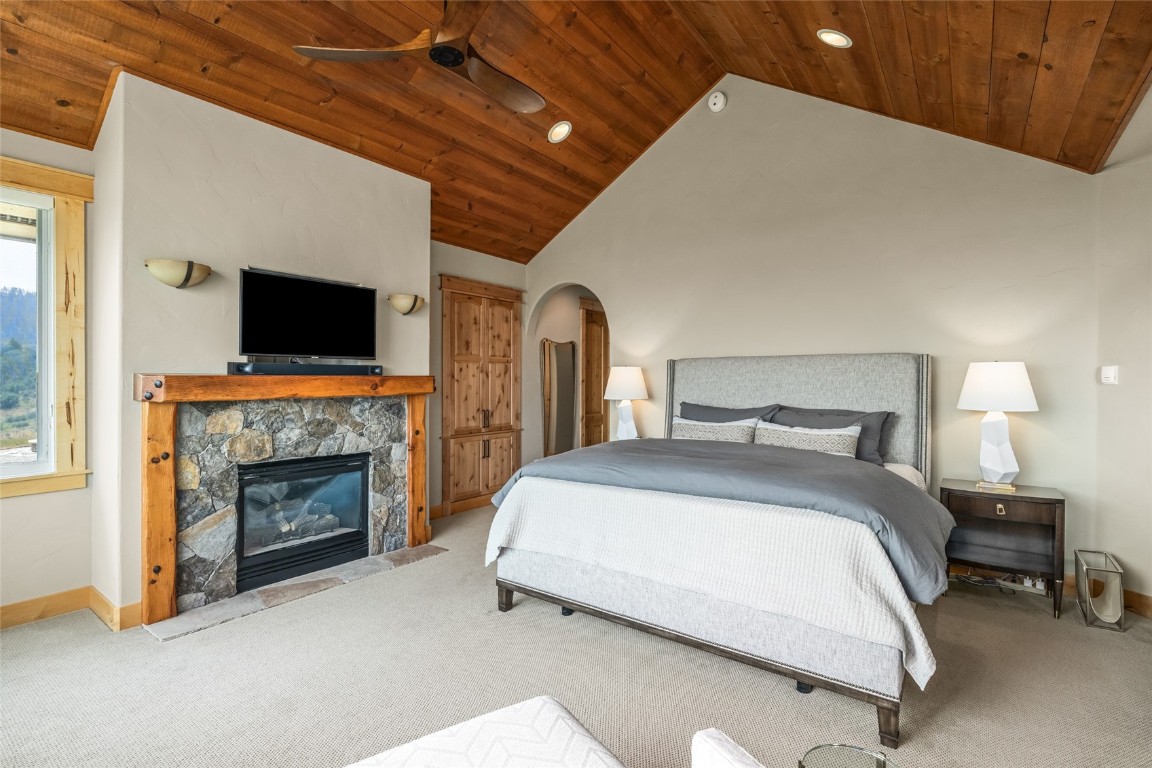 31105 Country Side Road Steamboat Springs, CO 80487 - Photo 29 of 50 a spacious bedroom with a bed and a fireplace