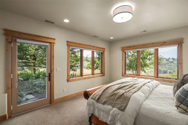 a bed sitting in a spacious bedroom next to a window