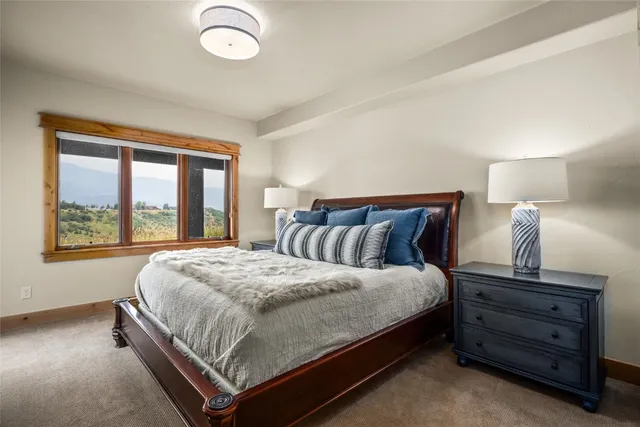 a large bed sitting in a bedroom next to a window