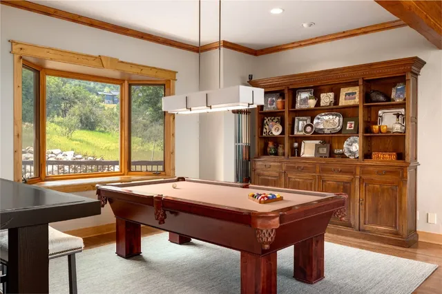 a room with pool table and windows