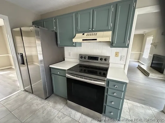 a kitchen with stainless steel appliances a stove a refrigerator and cabinets