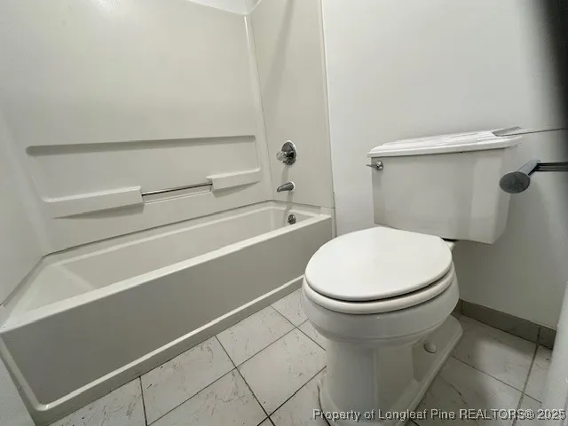 a white toilet sitting next to a bath tub