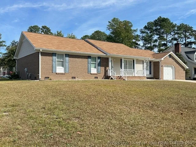 a front view of house with yard and trees around