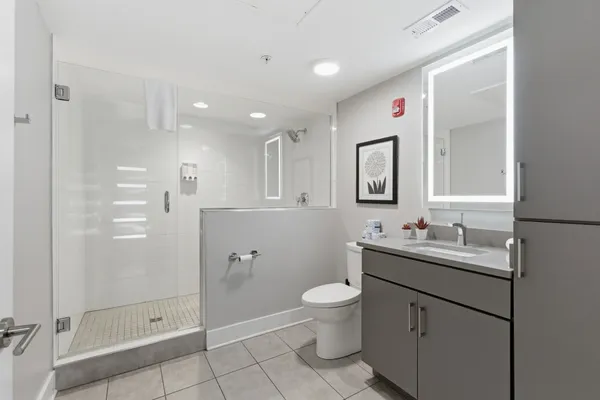 a bathroom with a toilet sink double vanity and mirror