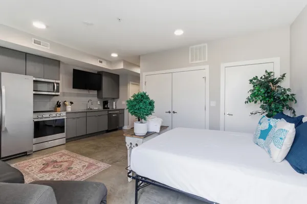 a bedroom with a bed window and potted plant