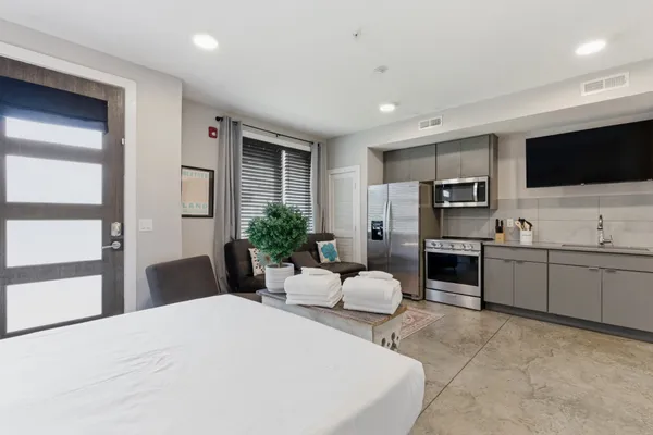 a large white room with kitchen island furniture and a flat screen tv