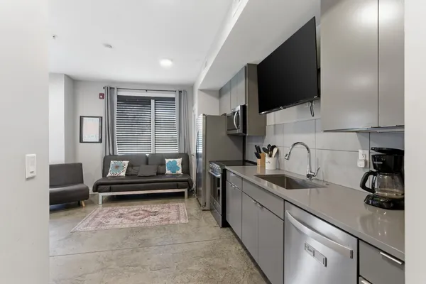 a kitchen with stainless steel appliances granite countertop a sink and a stove top oven