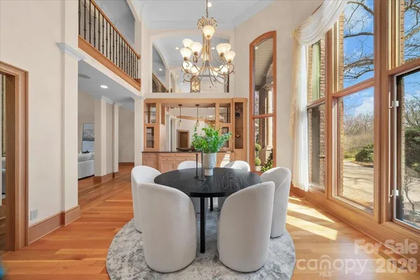 a dining room with furniture a chandelier and wooden floor