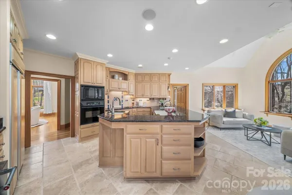a kitchen with stainless steel appliances kitchen island granite countertop a refrigerator and cabinets