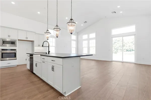 a kitchen with stainless steel appliances granite countertop a sink a stove and a window