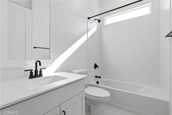 a bathroom with a sink a toilet a mirror and shower